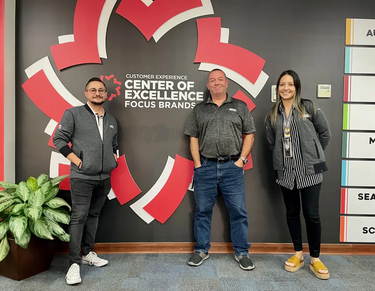 Johnny Tellez with two colleagues at the Focus Brands Customer Experience Center of Excellence